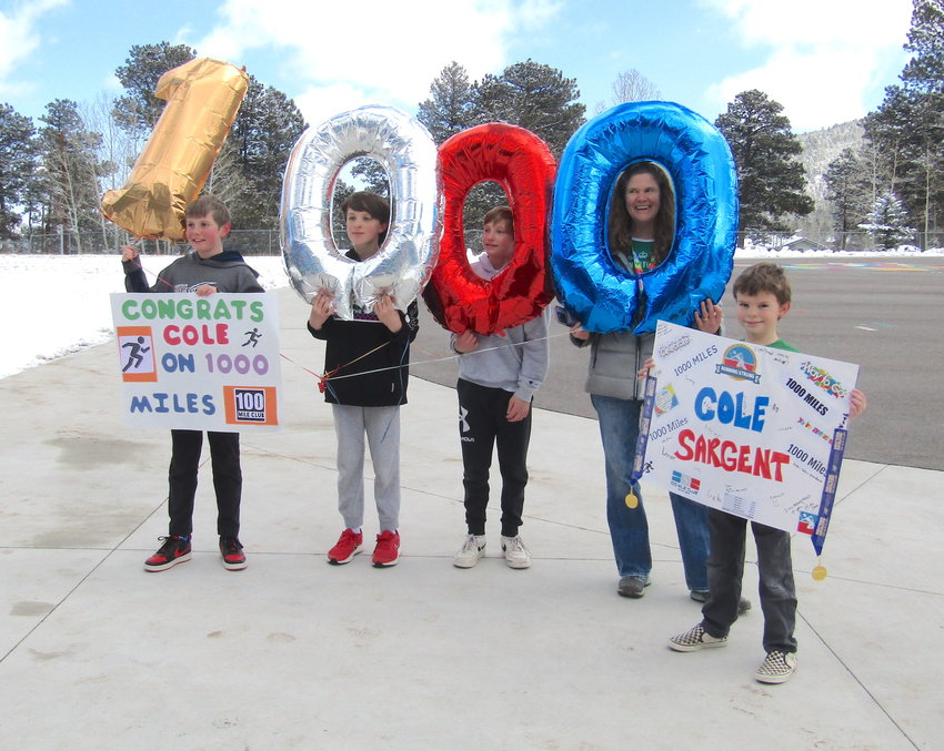 Cole Sargent, a fifth grader at West Jefferson Elementary School, celebrated 1,000 miles since he started kindergarten. Sargent and his friends, along with 100 Mile Club coordinator Christine Olsen, holding the blue 0, celebrated his achievement on March 17.